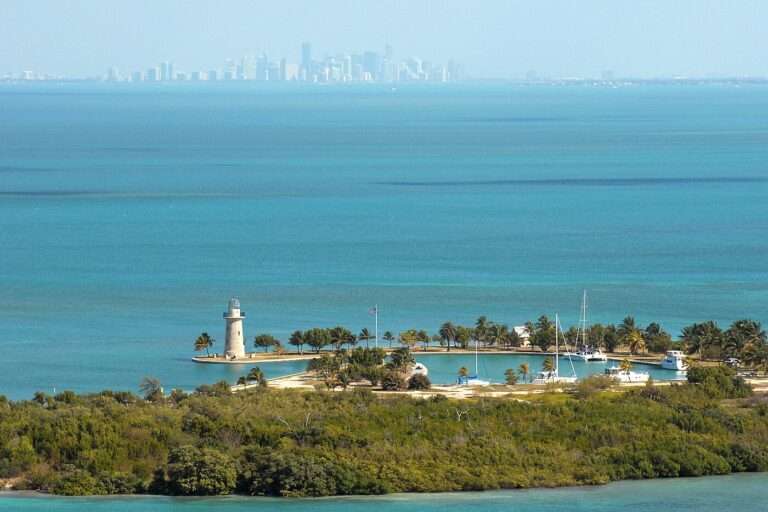 Boca Chita Key's ornamental lighthouse and palm-lined harbor with the Miami skyline on the horizon